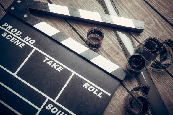 Film. Movie clapper and film reel on a wooden background