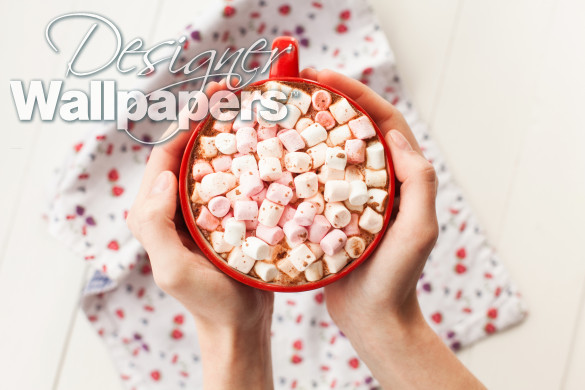 Hands holding hot chocolate with marshmallows in cup