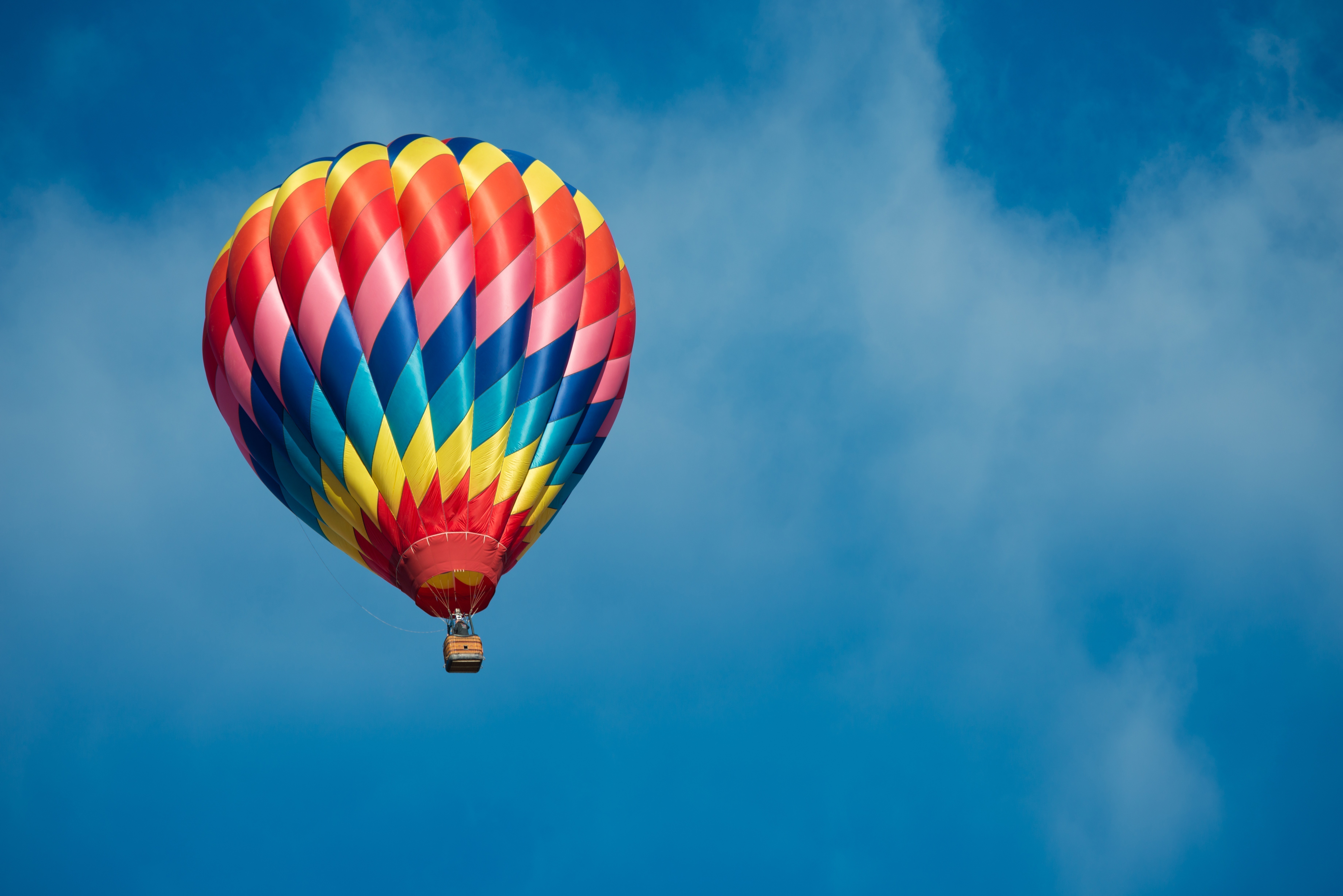 Brightly colored hot air balloon with a sky blue background - Multicolour -  Colours - Canvas Prints | Wonder Wall