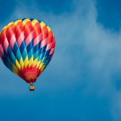 Brightly colored hot air balloon with a sky blue background