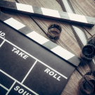 Film. Movie clapper and film reel on a wooden background