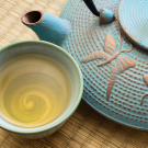 Oriental cast iron tea pot with tea cup on tatami mat