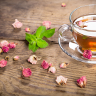 Cup of green tea with mint and dried roses