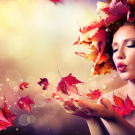 Autumn woman blowing red leaves