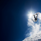 Snowboarder making high jump in clear blue sky