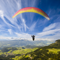 Paraglider flying over mountains