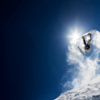 Snowboarder making high jump in clear blue sky