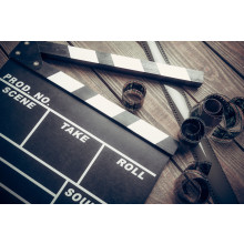 Film. Movie clapper and film reel on a wooden background