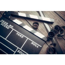 Film. Movie clapper and film reel on a wooden background