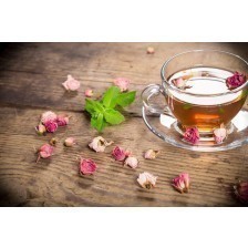Cup of green tea with mint and dried roses