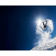 Snowboarder making high jump in clear blue sky