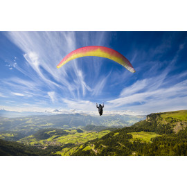 Paraglider flying over mountains