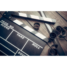Film. Movie clapper and film reel on a wooden background